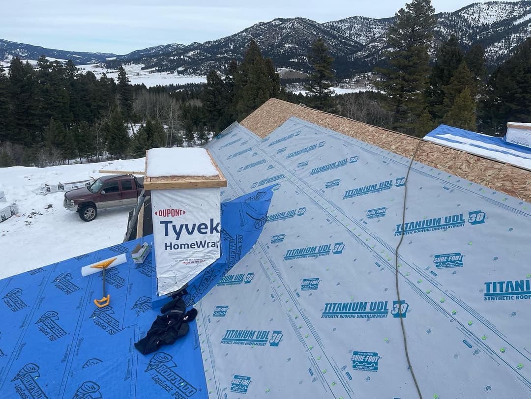 Roofing installation with Tyvek HomeWrap and Titanium UDL 30 on a snowy mountain landscape.